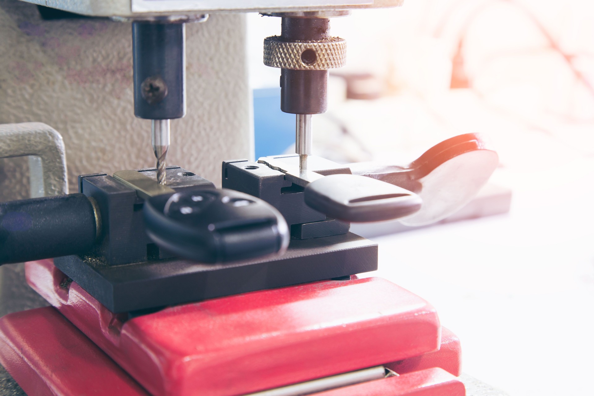 Locksmith in workshop makes new key. Professional making key in locksmith.